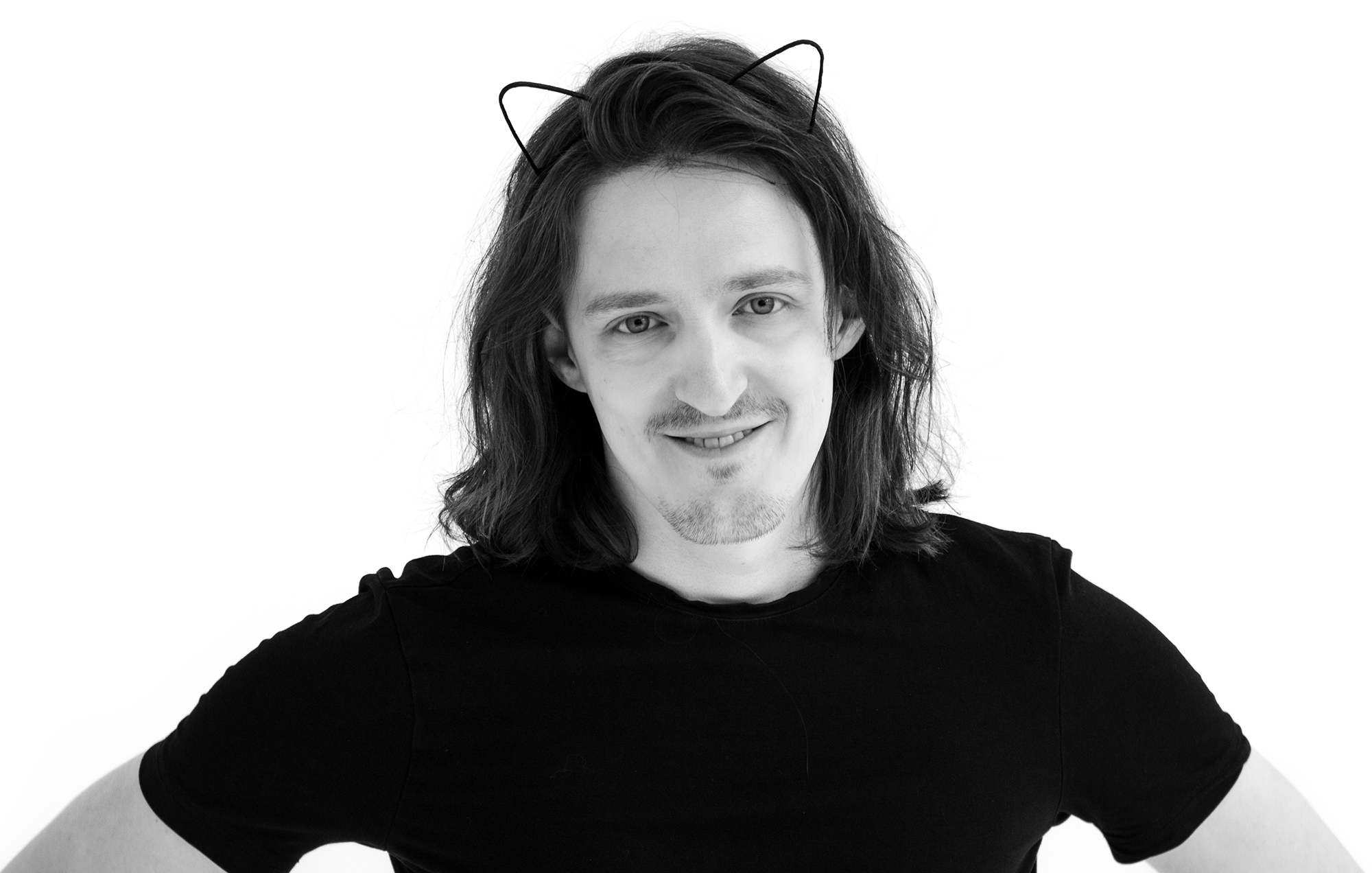 Black and white portrait of Denis Sokolov smiling and wearing cat ears.